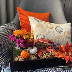 Orange woven jacquard pumpkin pattern lumbar pillow cover for Halloween & Fall home decor. Ideal for modern or country style home decor, the oblong cushion cover is set on a grey chair paired with a solid orange velvet throw pillow cover from The HomeCentric. A tray is place with the pillows on chair with maple leaves, burlap pumpkins and flower arrangement in fall hues. The look is finished with a black and white monochrome checkered throw. Explore more of fall & Halloween Collection by The HomeCentric!