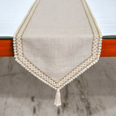 Styled overhead shot of beige table runner with white dinnerware