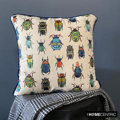 Beetle-printed pillow cover on a black chair with a checkered blanket, perfect for an eclectic home decor look.