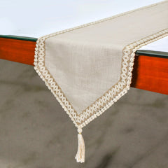 Beige linen table runner with lace trim draped over dining table