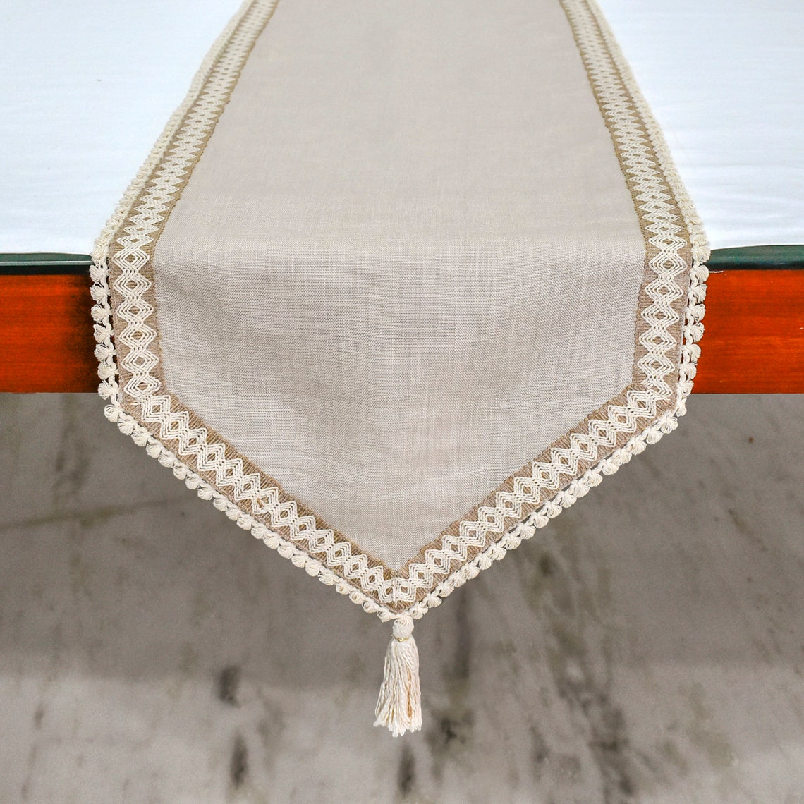 Styled overhead shot of beige table runner with white dinnerware