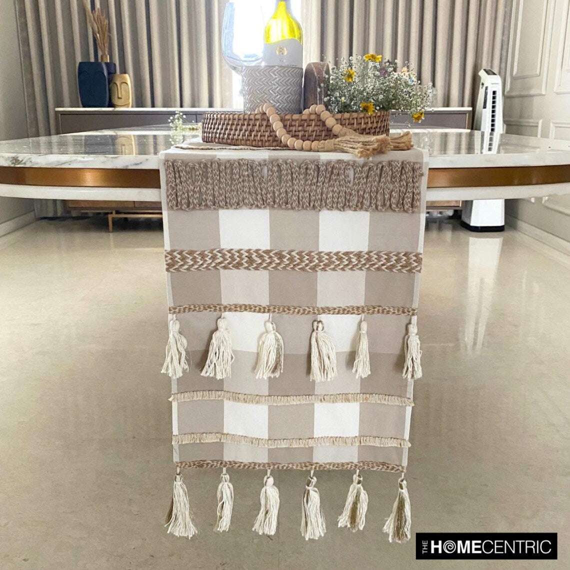 Close-up of buffalo check pattern on beige cotton table runner showing jute tassel detail