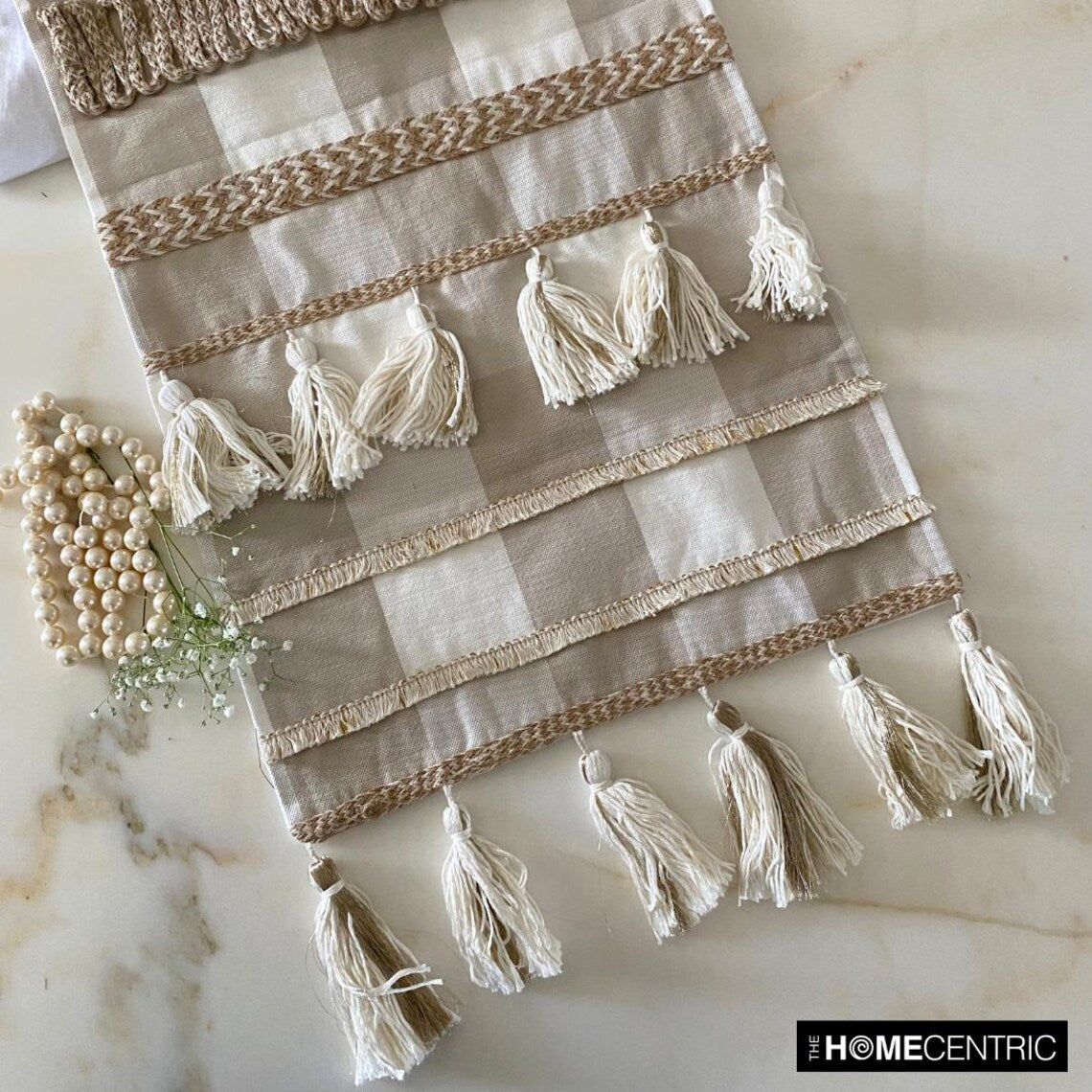 Detail shot of tassel fringe on beige buffalo check cotton table runner