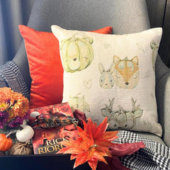 Fall Halloween home decor pillow cover, A woven jacquard throw pillow cover with pumpkin fox design and subtle fall colors for Autumn Decor set on a grey chair with a black throw and layered with an orange velvet pillow cover. Decorated with a tray containing maple leaves, pumpkin, book, and fall colored flowers, creating a perfect, cozy, and comfortable fall decor setting. Handcrafted pillow cover from The HomeCentric's Fall Collection.