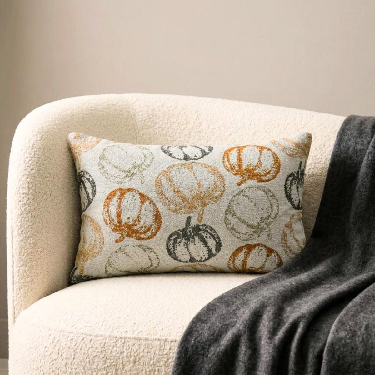 Orange woven jacquard pumpkin pattern lumbar pillow cover for Halloween & Fall home decor. Ideal for modern or country style home decor, the oblong cushion cover is set on a grey chair paired with a solid orange velvet throw pillow cover from The HomeCentric. A tray is place with the pillows on chair with maple leaves, burlap pumpkins and flower arrangement in fall hues. The look is finished with a black and white monochrome checkered throw. Explore more of fall & Halloween Collection by The HomeCentric!