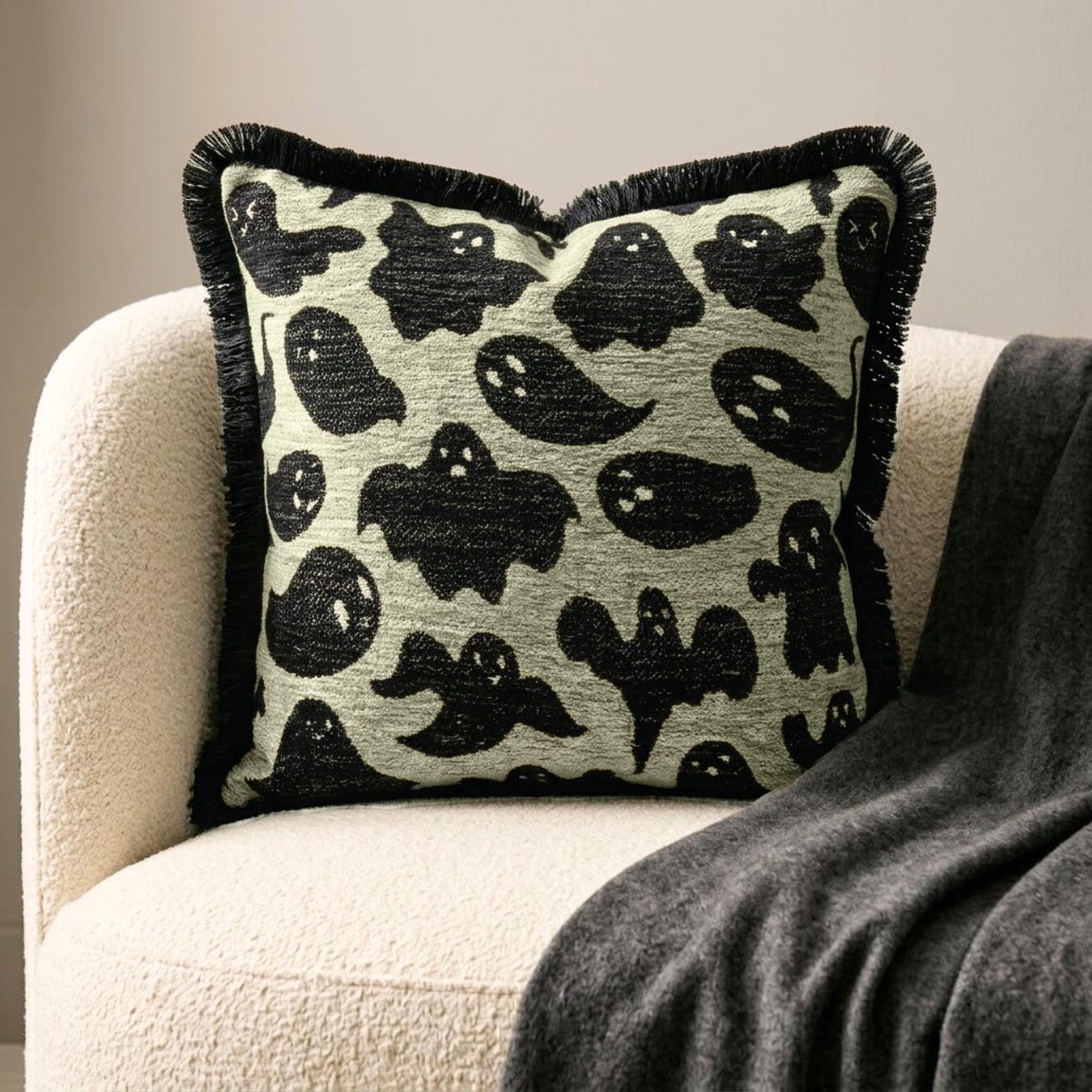 Skeleton holding ghost print throw pillow cover for Halloween decor such as a skull, a spider and a scary axe.