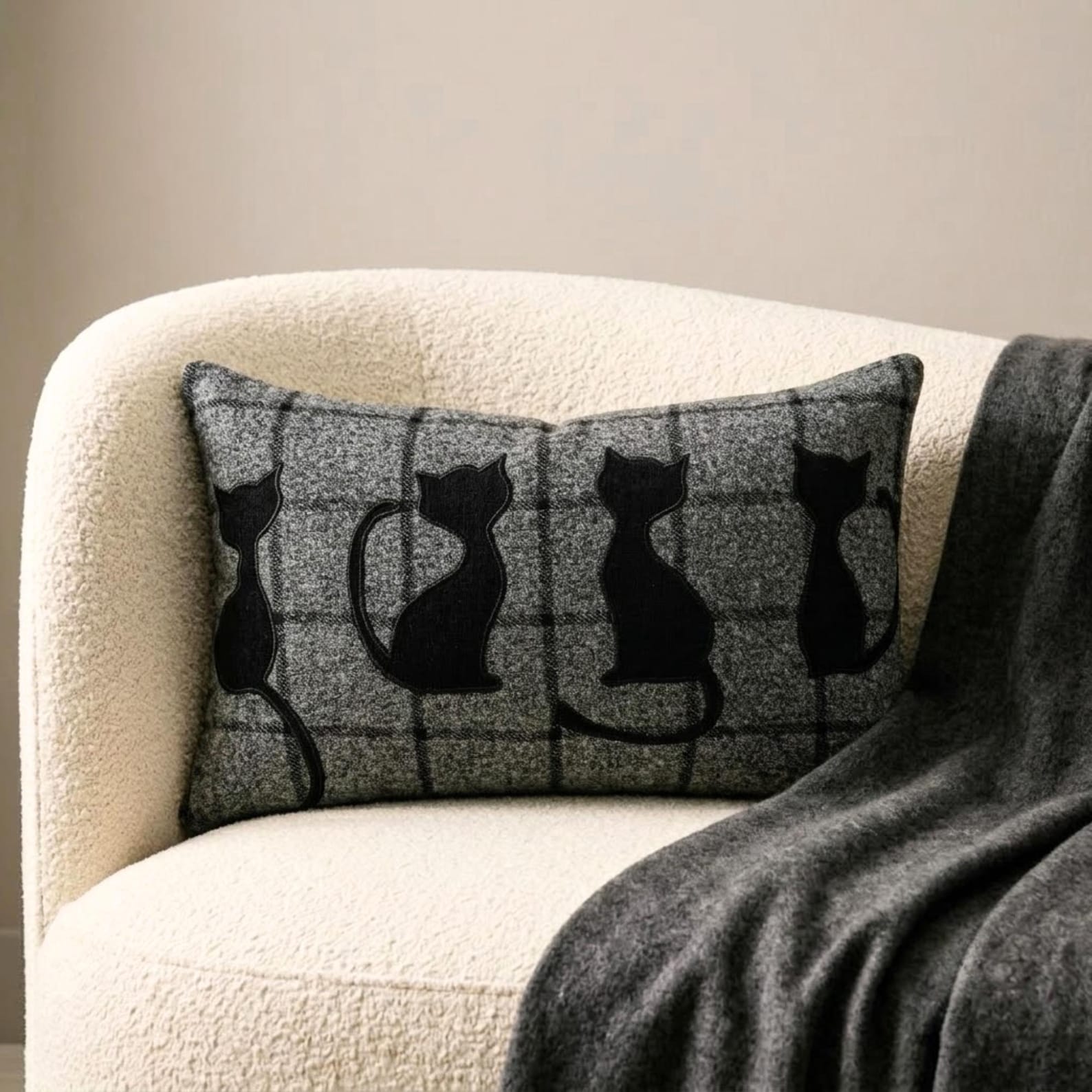 Halloween home decor featuring spooky black cat lumbar pillow cover with plaid design on a wool fabric, skeleton prop, spider webs, and eerie decorations creating a haunting Halloween vibe!